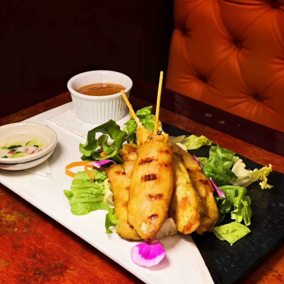 Grilled chicken satay skewers with peanut sauce and cucumber salad at Grata Thai Cuisine.
